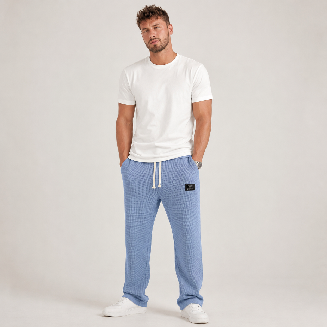 Homme en pantalon large bleu ciel en maille gaufrée et t-shirt blanc, baskets blanches