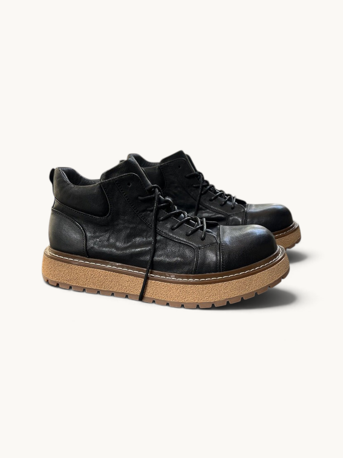 By Old Money black full-grain leather work boots with a thick lugged tan sole and mid-height ankle support.