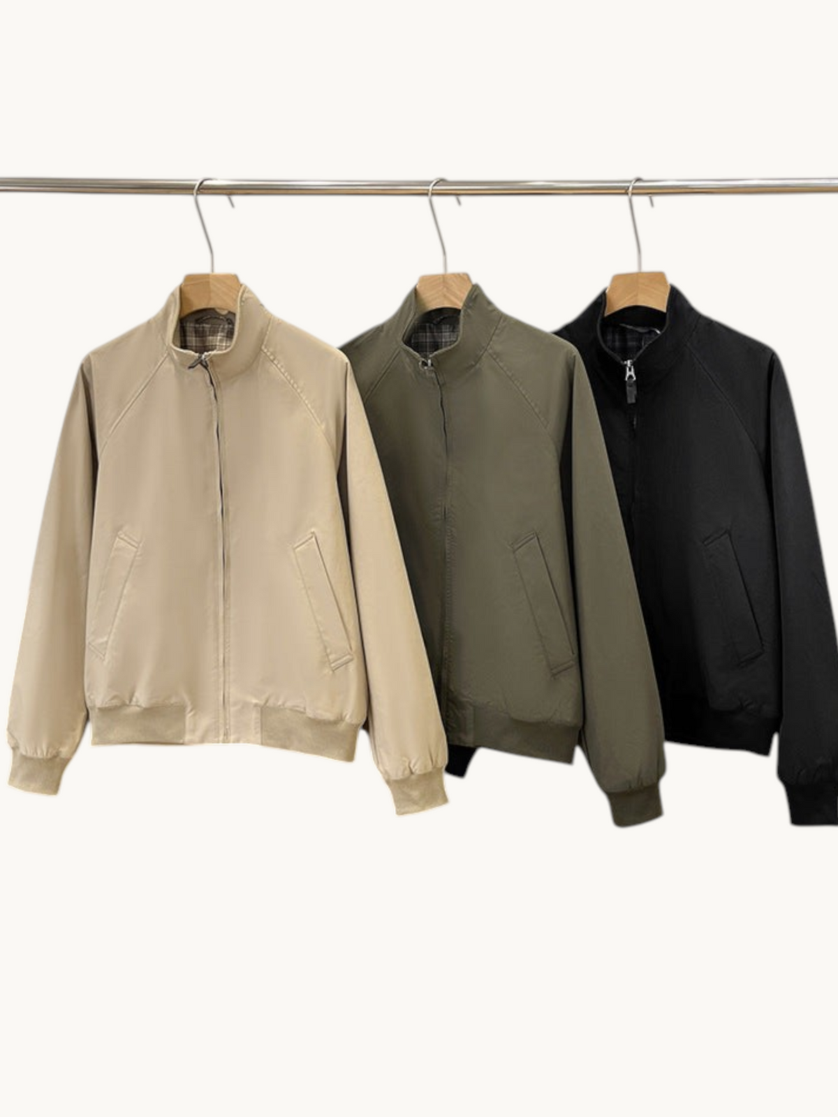 By Old Money lightweight blouson jackets with stand-up collars in beige, olive green, and black on a clothing rack.