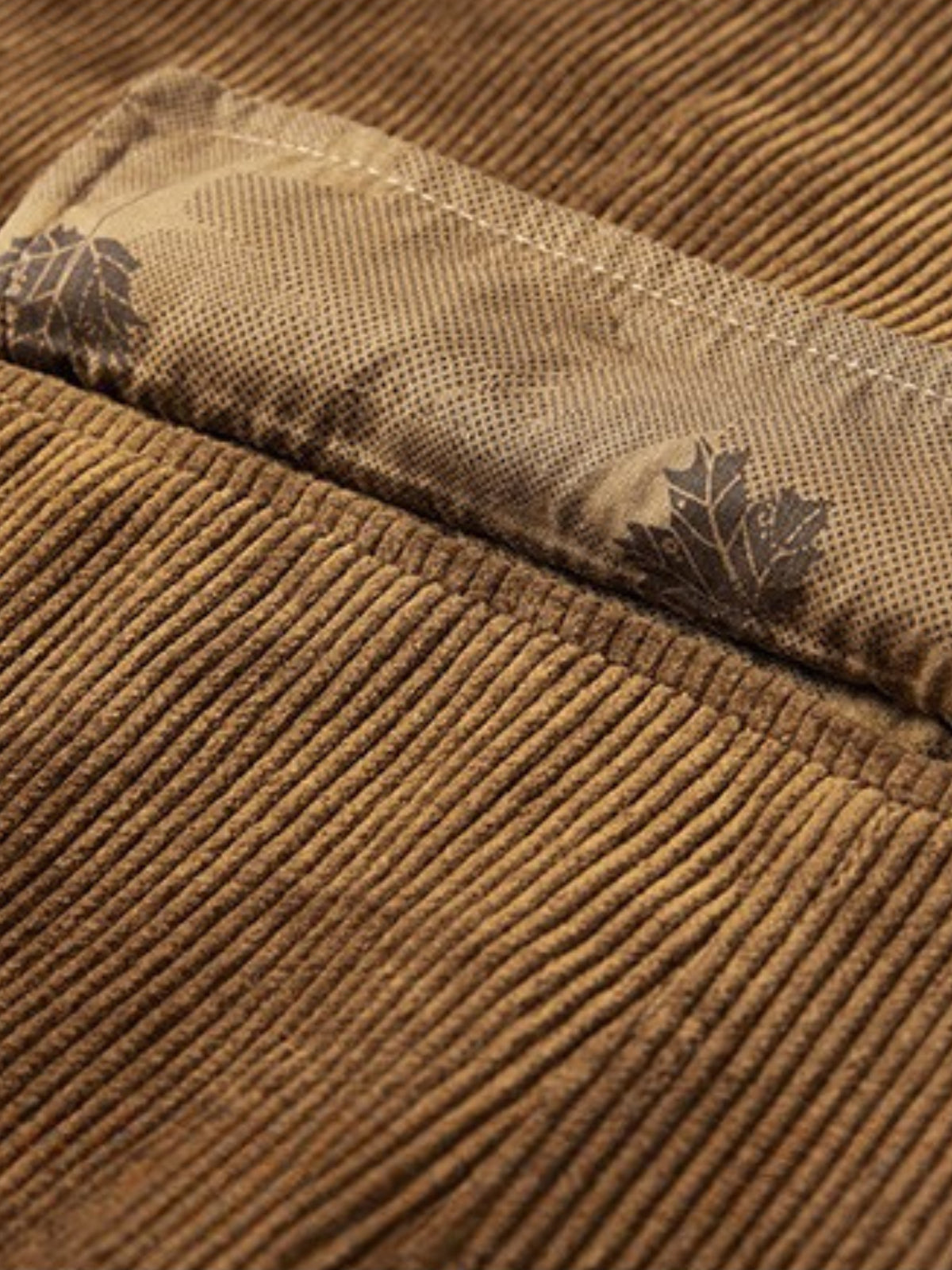 Détail du velours côtelé camel et de la doublure imprimée à feuilles
