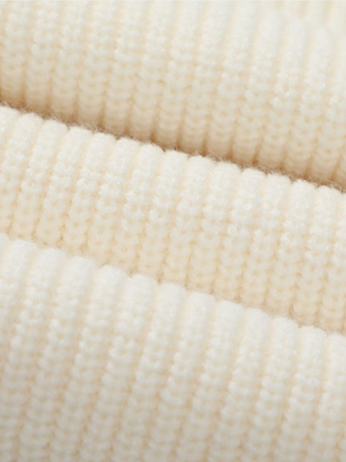 Détail des côtes larges de la maille crème du cardigan