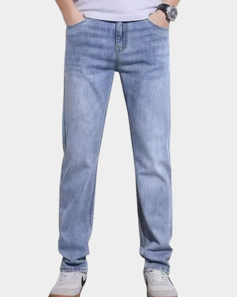 Jean coupe étroite bleu délavé, porté avec un t-shirt blanc et des baskets