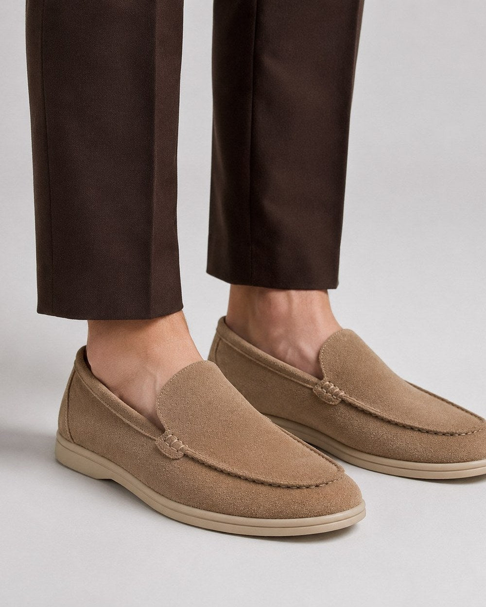 Mocassins en daim taupe portés avec un pantalon brun à pli