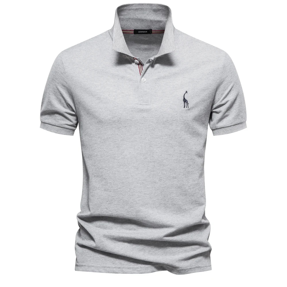 Polo en piqué gris clair chiné, col à liseré rayé et petite girafe brodée sur la poitrine