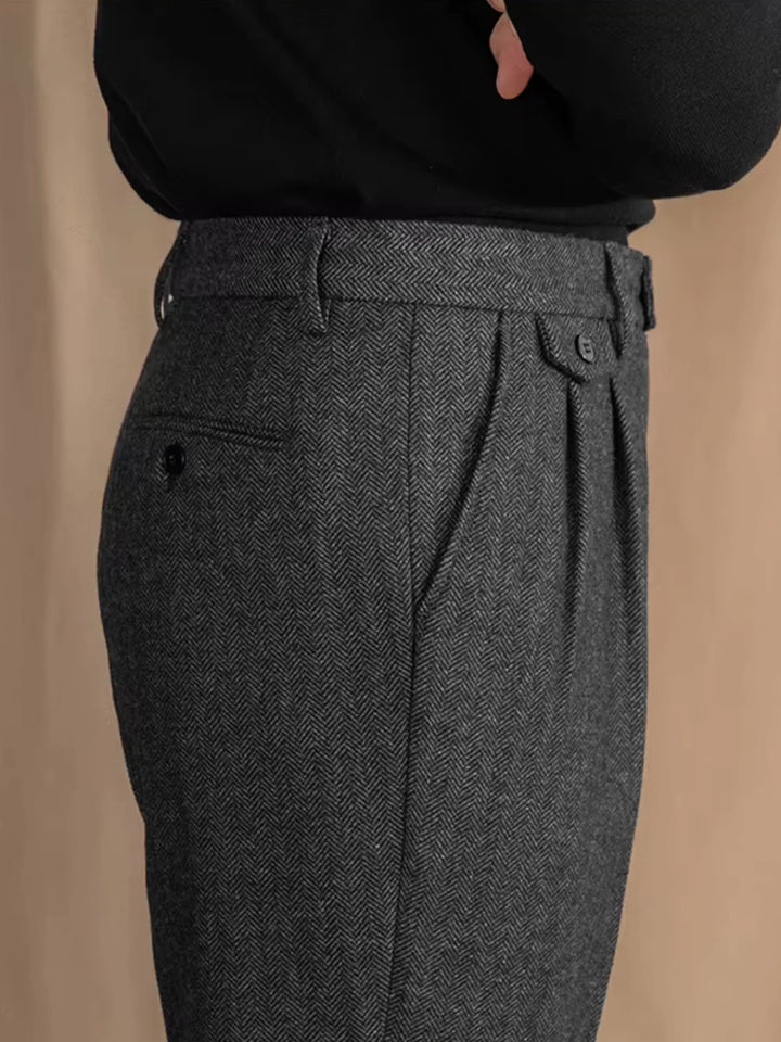 Pantalon à plis en chevrons gris porté de côté avec un haut noir