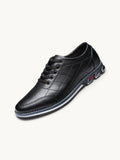 Chaussure basse en cuir noir matelassé avec semelle grise, lacets noirs et détail logo rouge sur le talon