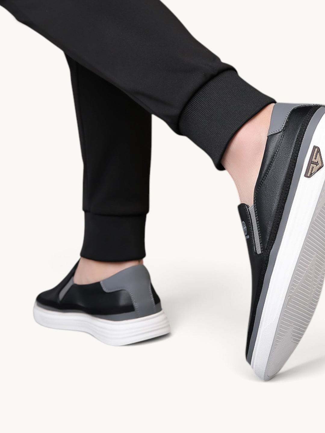 Mocassins noirs et gris à semelle plateforme blanche portés avec un pantalon noir
