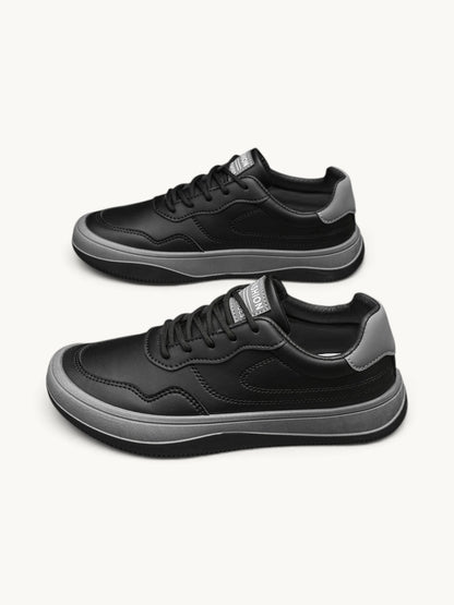 Paire de baskets basses noires en cuir à semelle grise, vue de côté