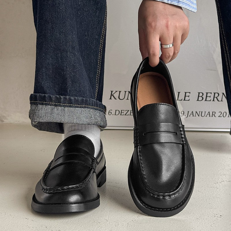 Mocassins noirs en cuir portés avec un jean, homme ajustant la chaussure droite