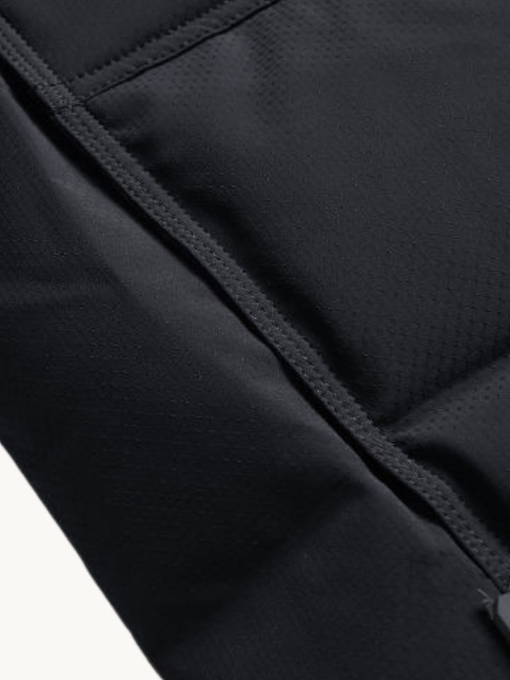 Gros plan sur la couture et le tissu noir matelasse de la doudoune