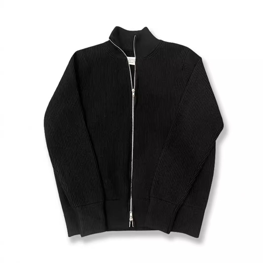 Cardigan noir en maille côtelée à col cheminée et double zip, posé à plat sur fond blanc