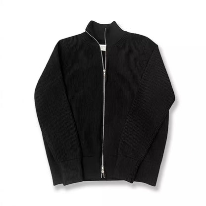 Cardigan noir en maille côtelée à col cheminée et double zip, posé à plat sur fond blanc