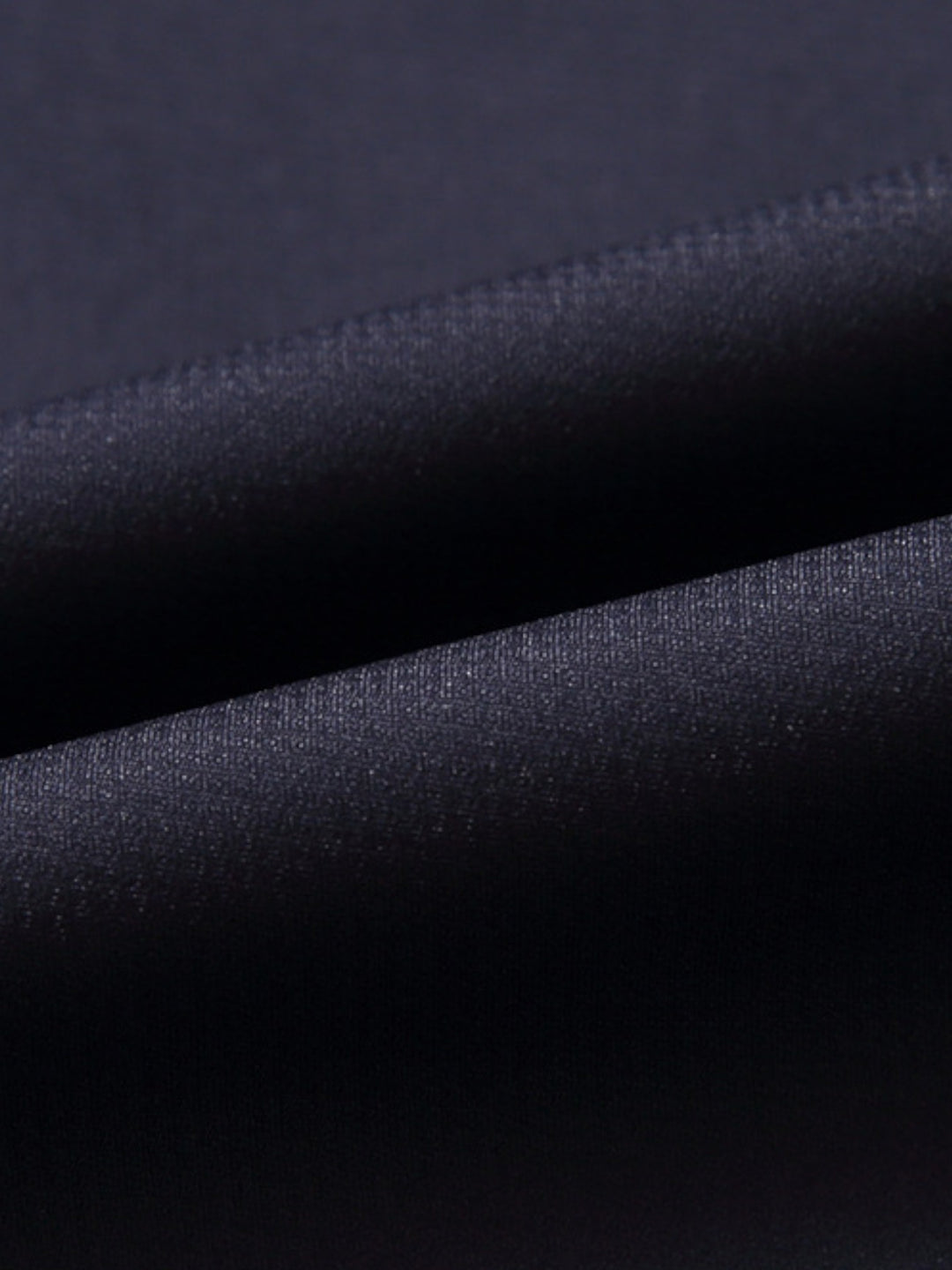 Manteau de laine texturé noir, détail du col classique et tissu épais