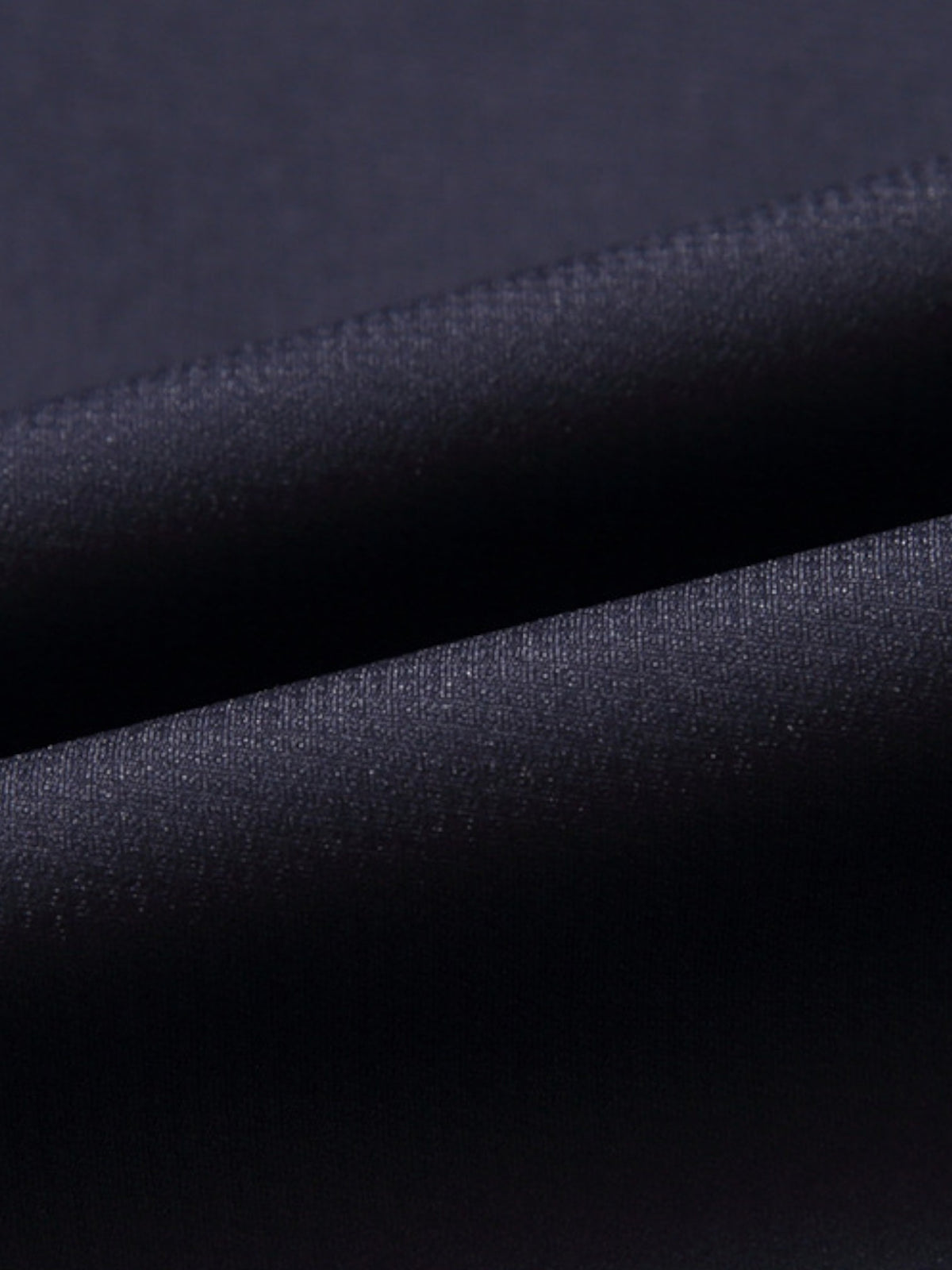 Manteau de laine texturé noir, détail du col classique et tissu épais