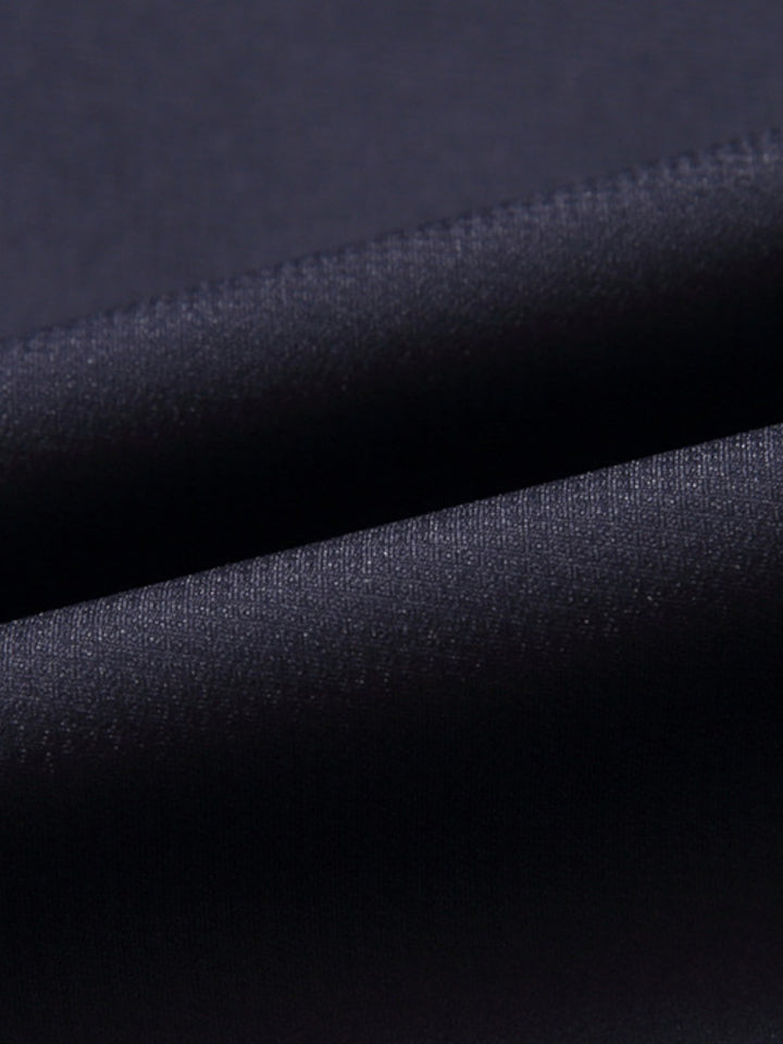 Manteau de laine texturé noir, détail du col classique et tissu épais