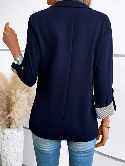 Blazer bleu marine vu de dos, couture médiane et manches retroussées à poignets rayés