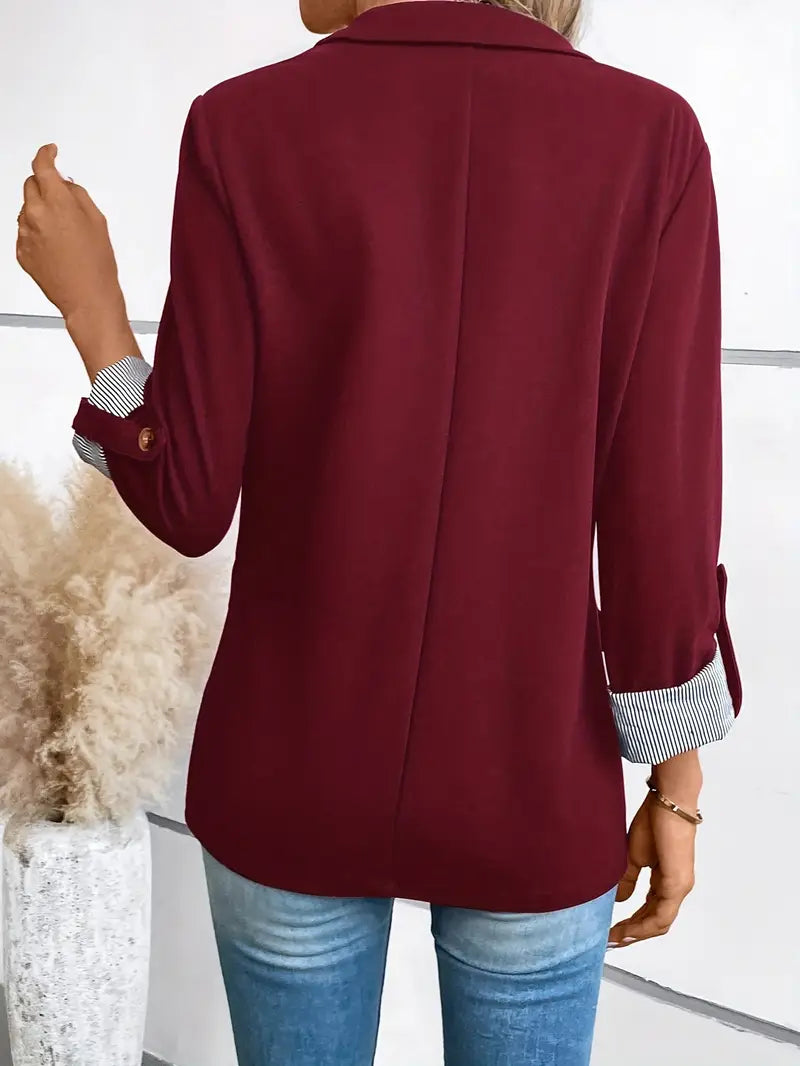 Blazer cramoisi vu de dos, couture médiane et manches retroussées à poignets rayés