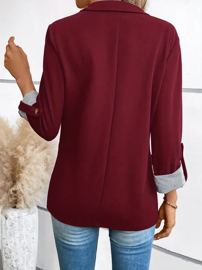 Blazer cramoisi vu de dos, couture médiane et manches retroussées à poignets rayés