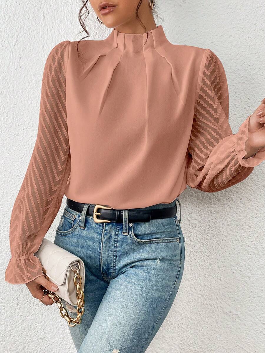 Blouse col montant plissée, coloris rose poudré, porté en tenue