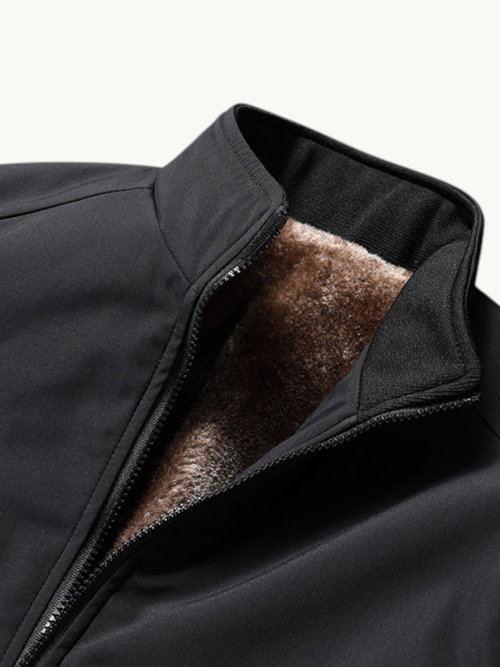Blouson bombardier noir zippé ouvert, montrant la doublure polaire marron chiné