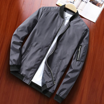 Blouson bomber gris foncé posé à plat sur un tee-shirt