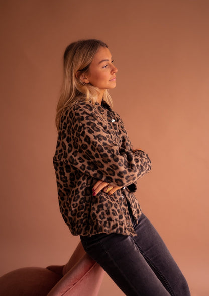 Blouson imprimé léopard vu de profil, bras croisés