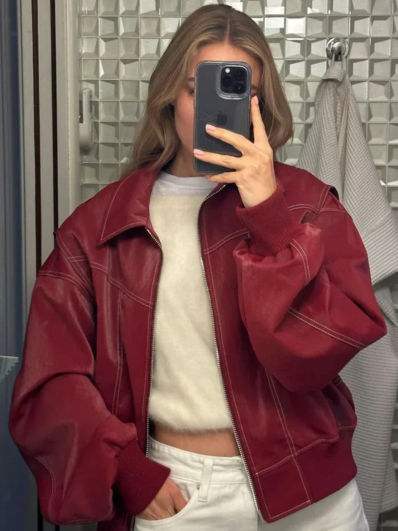 Blouson rouge cerise ouvert sur un pull clair, photo au miroir