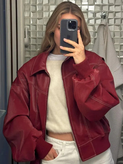 Blouson rouge cerise ouvert sur un pull clair, photo au miroir