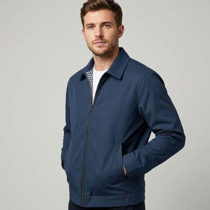 Blouson zippé bleu marine porté fermé, main en poche
