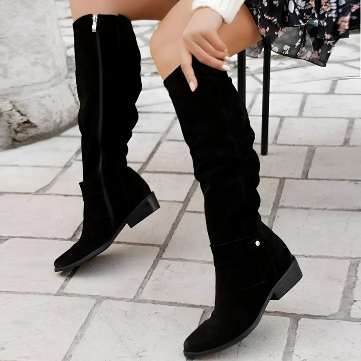 Bottes hautes noires à tige froissée, vue de profil en marchant