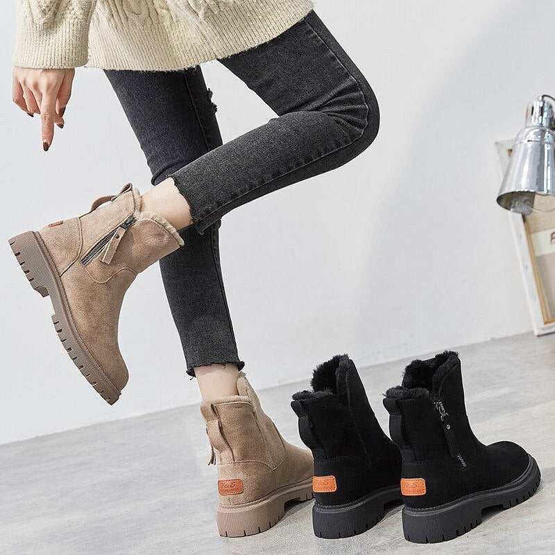 Bottines beige et noire à cols pelucheux, portées avec un jean
