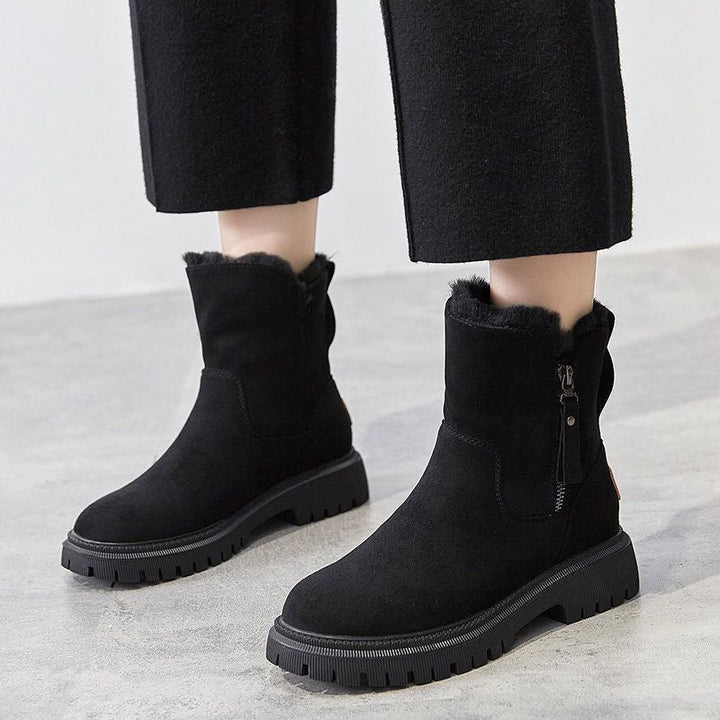 Bottines noires à cols pelucheux sur plateformes crantées, portées