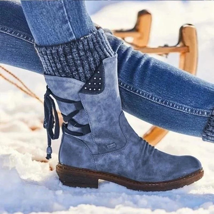 Bottine bleue à revers en maille et laçage arrière, portée dans la neige