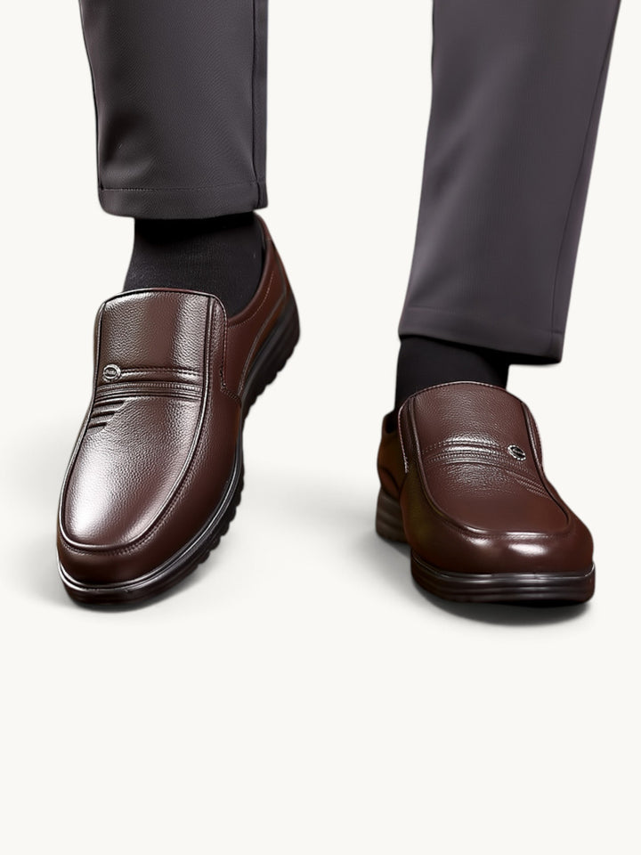 Mocassins en cuir marron semi-brillant portés avec costume gris, vue détail des pieds