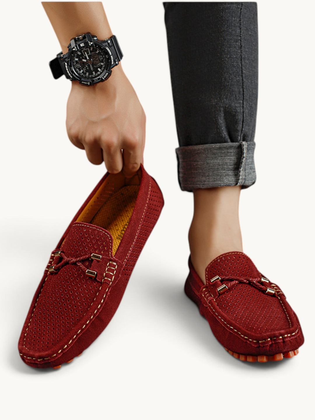 Mocassins bordeaux en cuir perforé portés avec un pantalon gris retroussé