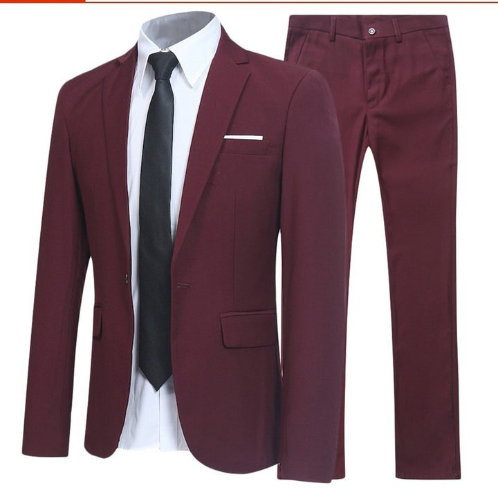 Costume deux pièces bordeaux, veste ajustée portée avec chemise blanche et cravate noire, pantalon assorti