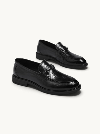 By Old Money black leather loafers with a polished finish, metal bit detail, and a classic slip-on silhouette.