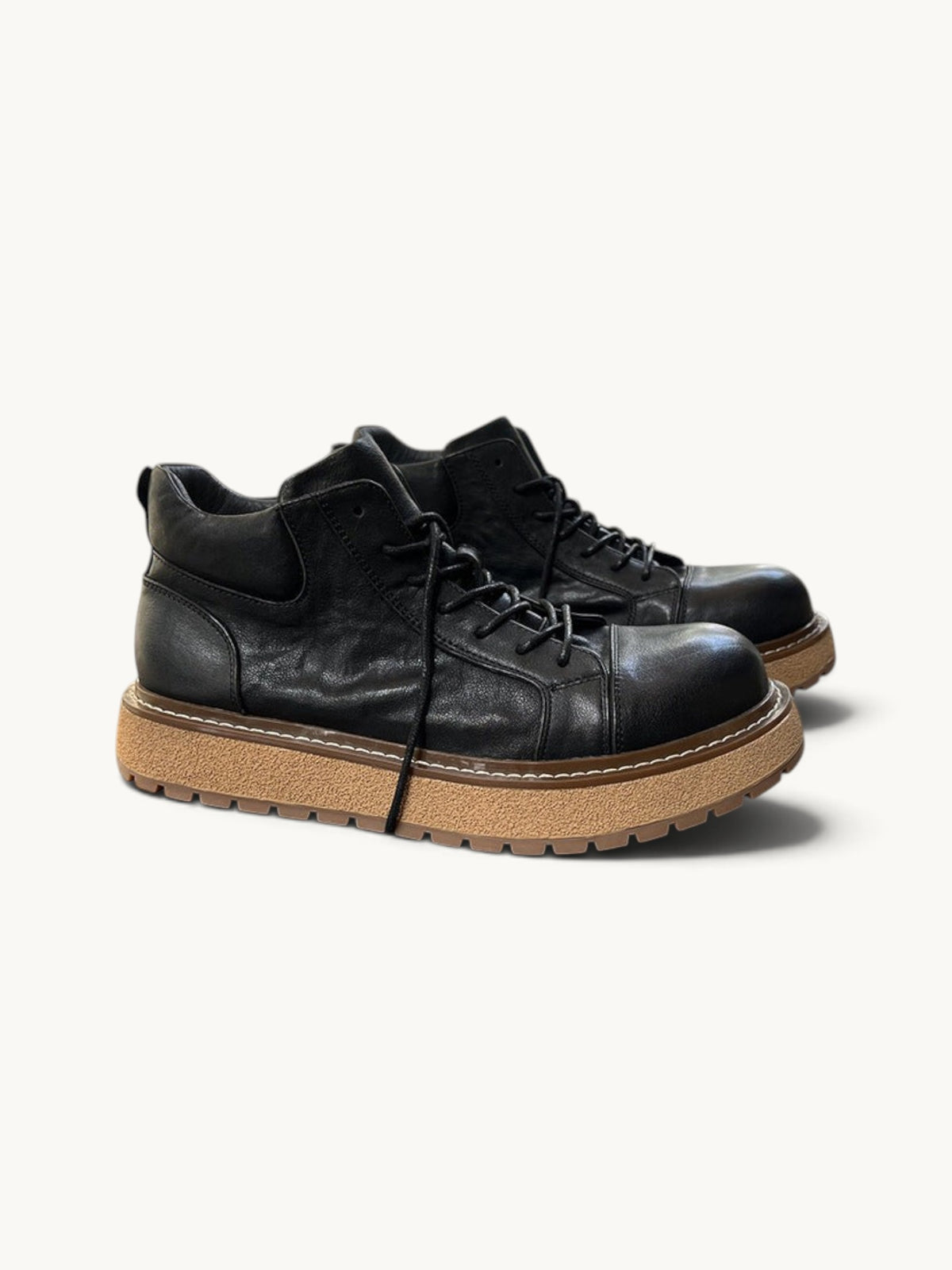 By Old Money black full-grain leather work boots with a thick lugged tan sole and mid-height ankle support.