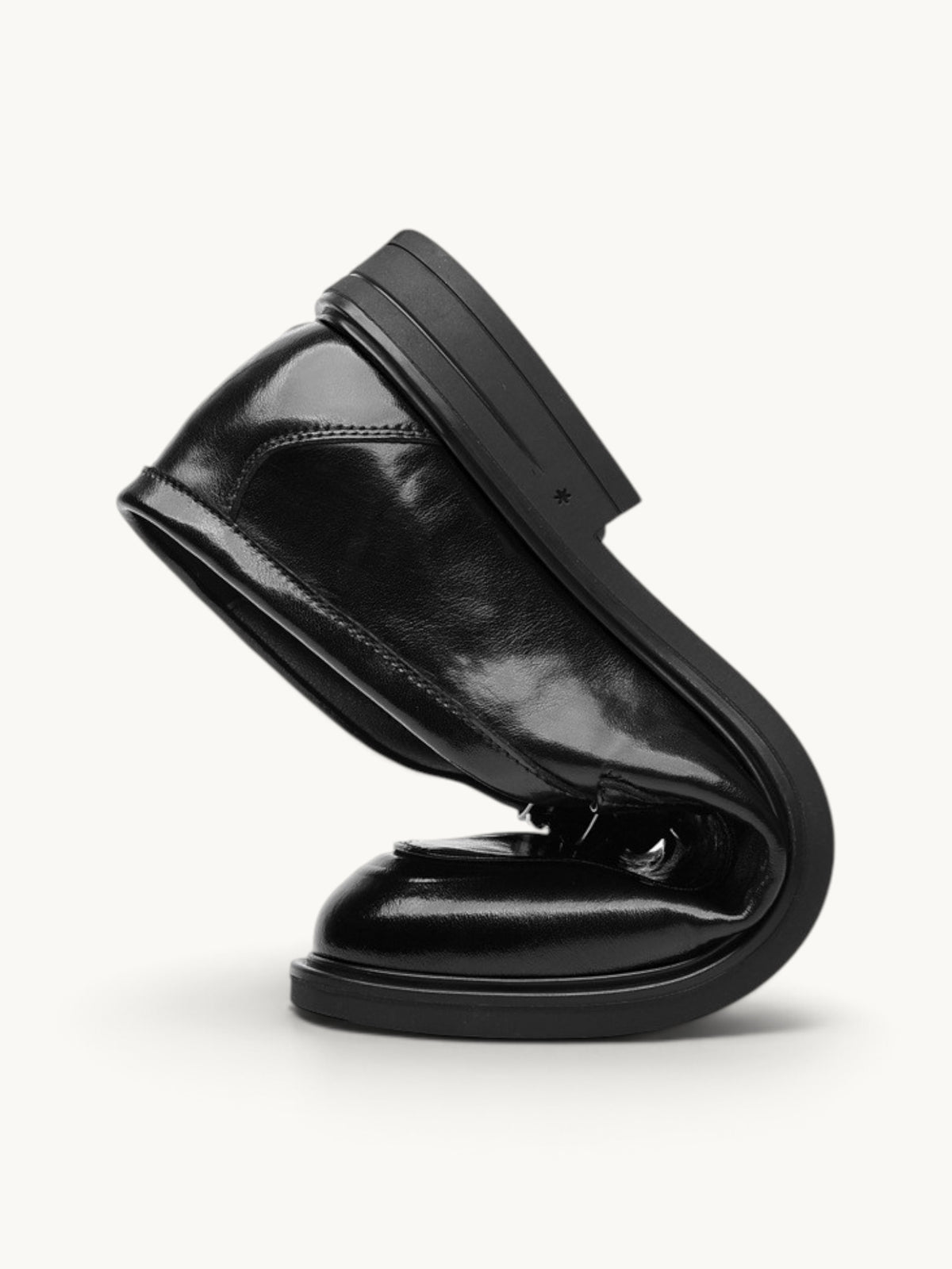 By Old Money black recycled leather dress shoe folded to demonstrate flexibility and soft construction