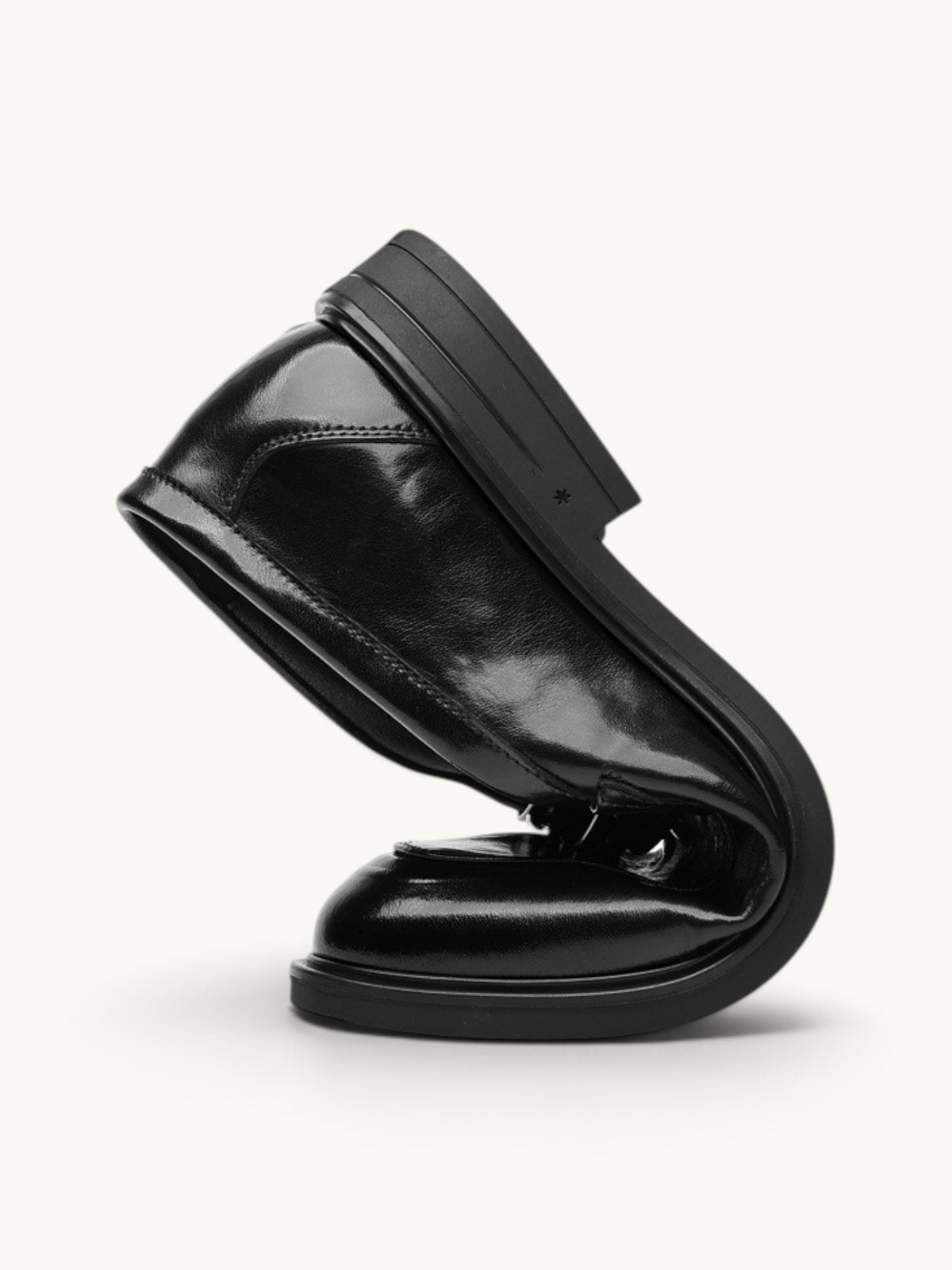 By Old Money black recycled leather dress shoe folded to demonstrate flexibility and soft construction