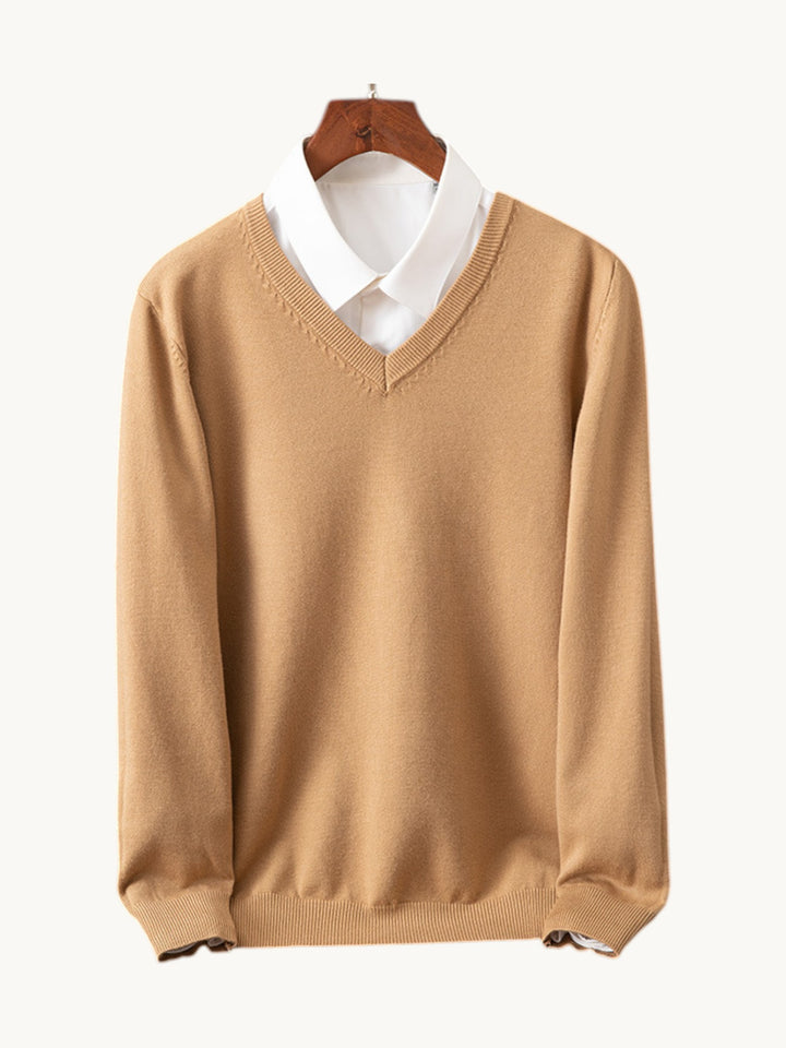 Pull camel à col en V sur cintre, porté sur une chemise blanche
