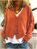 Cardigan court boutonné, coloris orange, porté en tenue