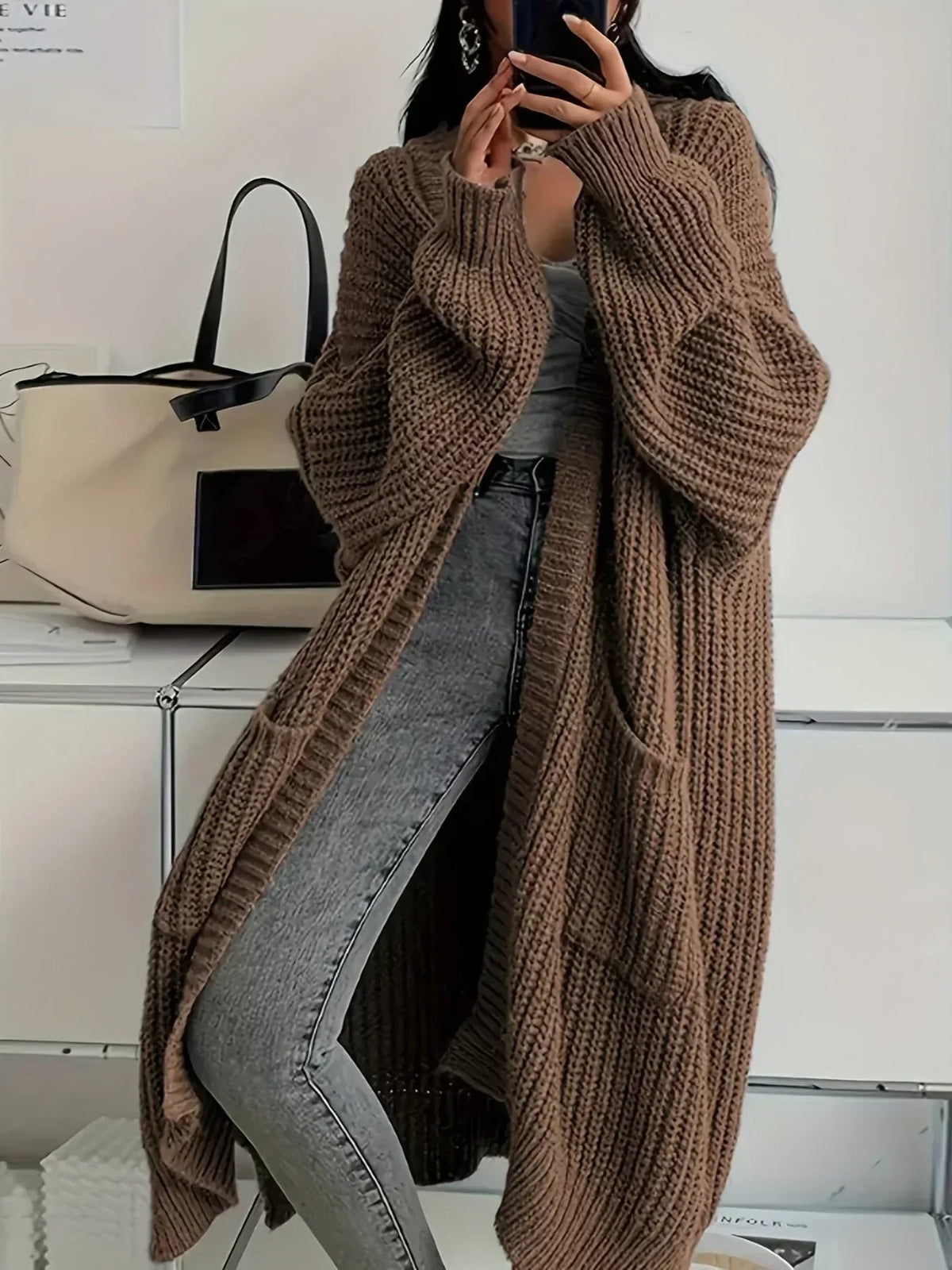 Cardigan long oversize marron en maille épaisse côtelée, porté avec un jean gris