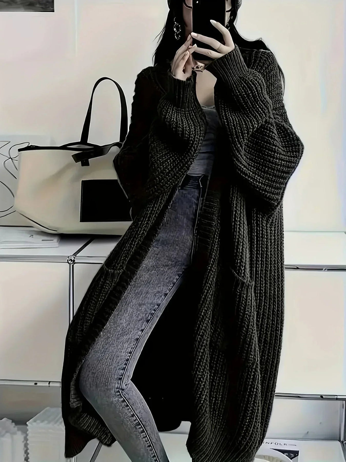 Cardigan long oversize noir en maille épaisse côtelée, porté avec un jean gris