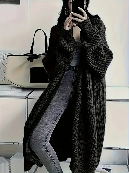 Cardigan long oversize noir en maille épaisse côtelée, porté avec un jean gris