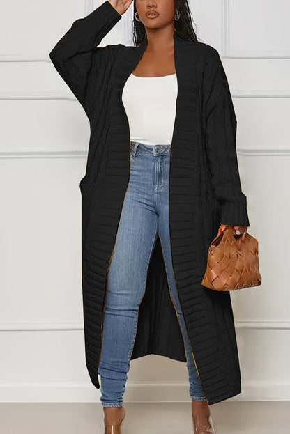 Cardigan long noir en maille torsadée, porté avec un jean et un haut blanc