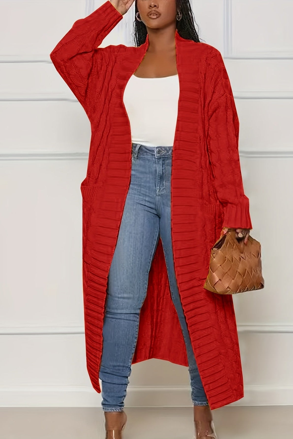 Cardigan long rouge en maille torsadée, porté avec un jean et un haut blanc
