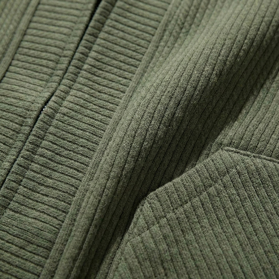 Gros plan sur la maille gaufrée vert kaki et l'entrée de poche du cardigan