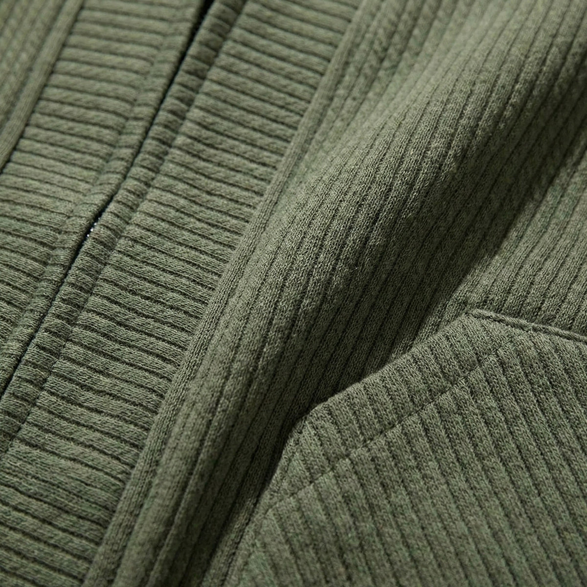 Gros plan sur la maille gaufrée vert kaki et l'entrée de poche du cardigan