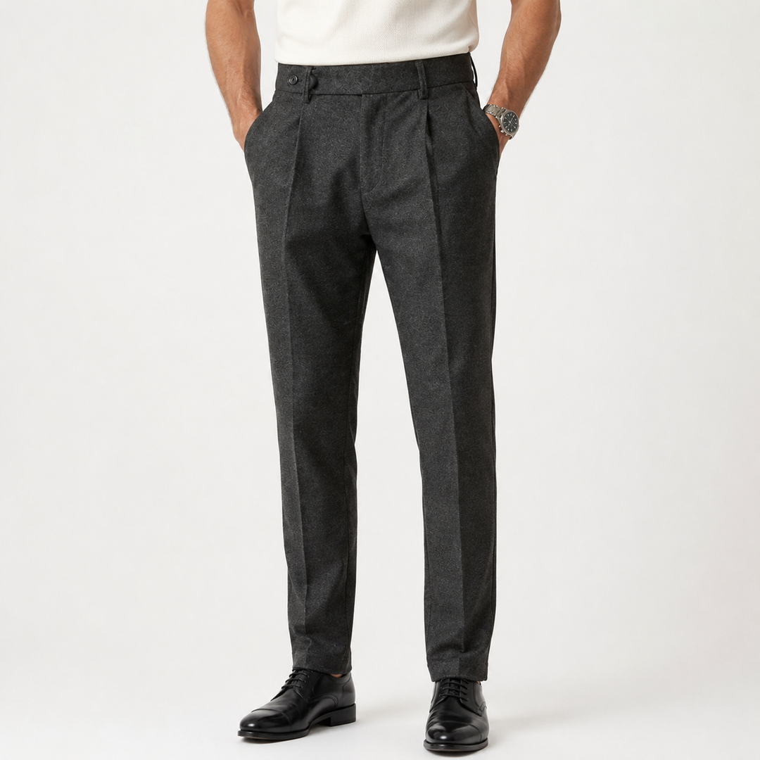 Charcoal wool tapered trousers with pleats and belt loops, worn by model